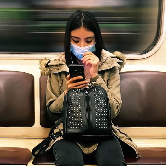 nominated-already-young-woman-wearing-a-medical-mask-in-subway-train-and-using-mobile-phone_t20_V7XdA1
